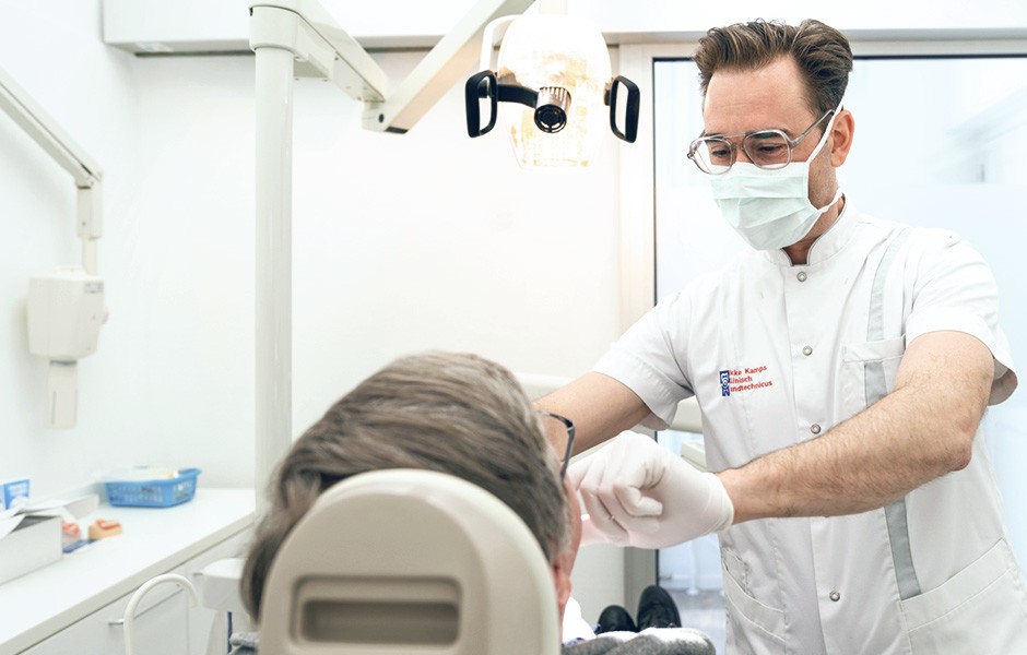 El protésico dental Okke Kamps y un paciente durante la prueba en boca de una prótesis.